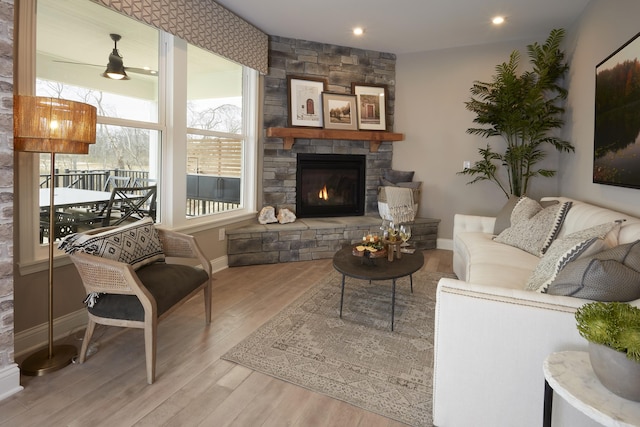 living area with recessed lighting, a fireplace, baseboards, and wood finished floors