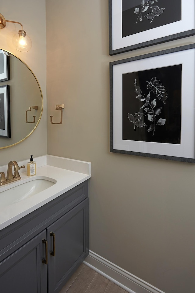 bathroom featuring vanity, wood finished floors, and baseboards