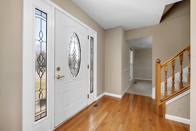 foyer featuring stairway, baseboards, visible vents, and light wood-type flooring