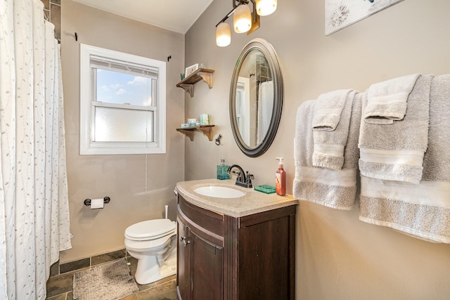 full bathroom featuring stone tile floors, toilet, vanity, and a shower with shower curtain