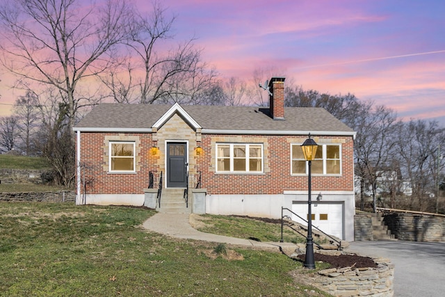 view of front of property with aphalt driveway, a garage, brick siding, and a chimney