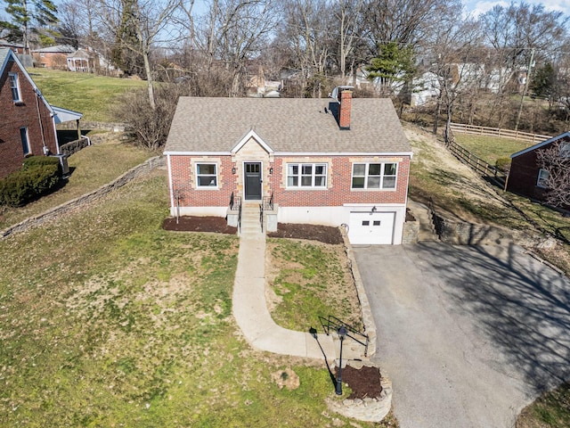 view of front of home with fence, driveway, an attached garage, a chimney, and brick siding