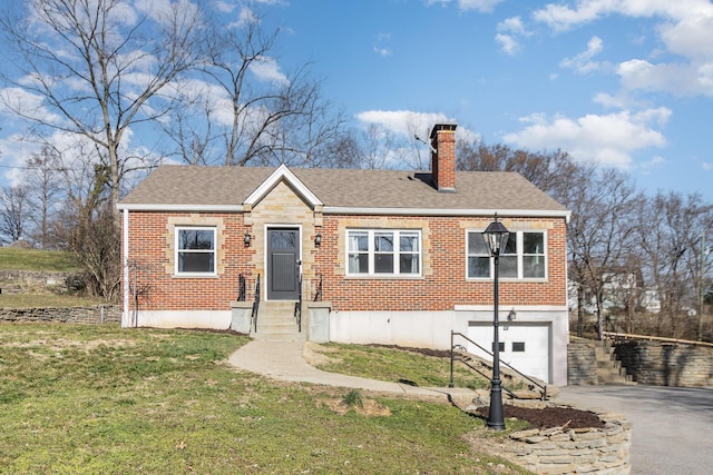 view of front facade featuring brick siding, aphalt driveway, a front yard, a chimney, and a garage