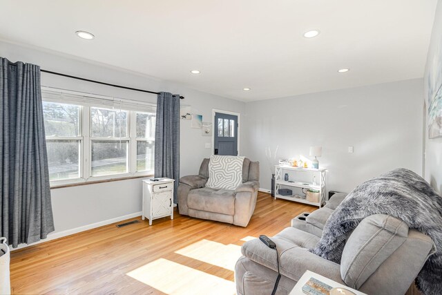 living room with recessed lighting, baseboards, and light wood-style floors