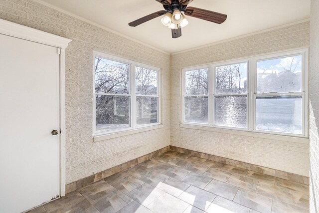 unfurnished sunroom featuring a ceiling fan