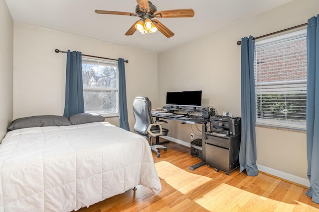 bedroom with baseboards, ceiling fan, and light wood finished floors