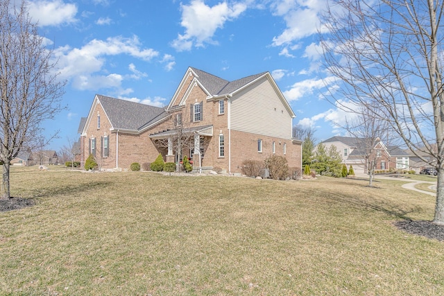 view of side of home with a yard and brick siding