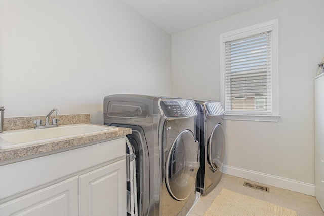 clothes washing area with light tile patterned floors, baseboards, visible vents, a sink, and washing machine and dryer