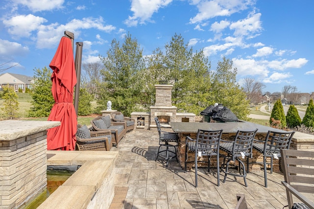 view of patio / terrace featuring outdoor dining area and an outdoor stone fireplace