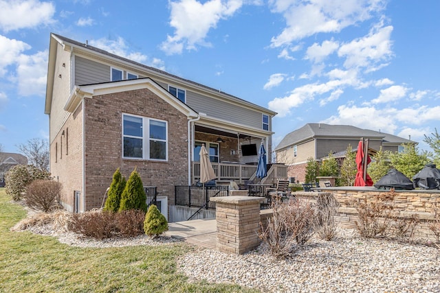 back of property featuring brick siding and a patio area