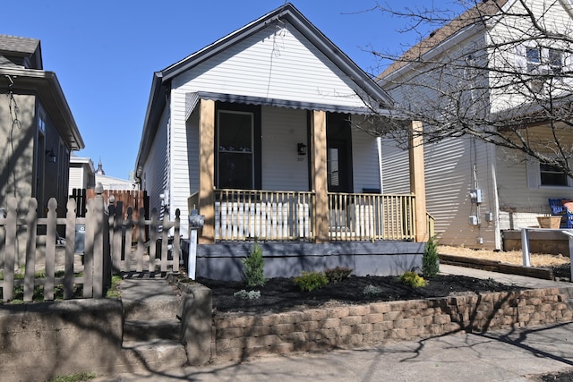 view of front facade with a porch and fence