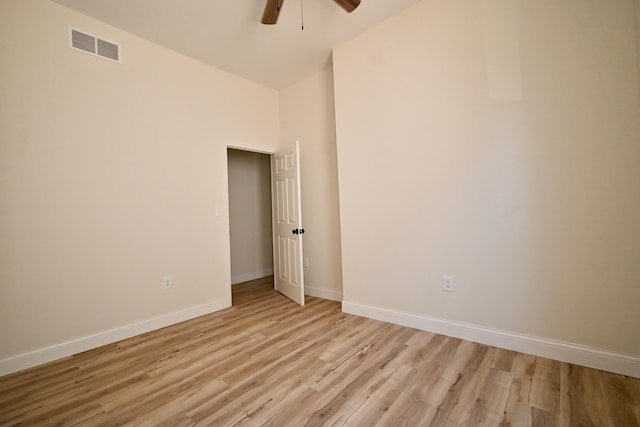 spare room featuring visible vents, light wood-style flooring, a ceiling fan, and baseboards