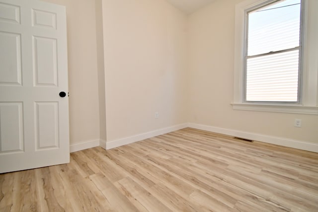 empty room with visible vents, baseboards, and light wood-type flooring