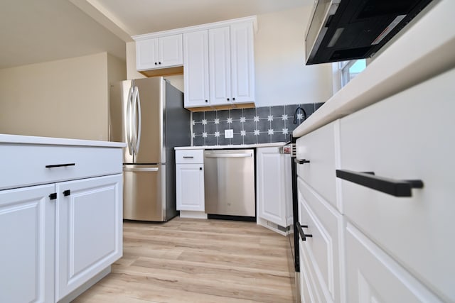 kitchen featuring light wood-style floors, stainless steel appliances, tasteful backsplash, and white cabinetry