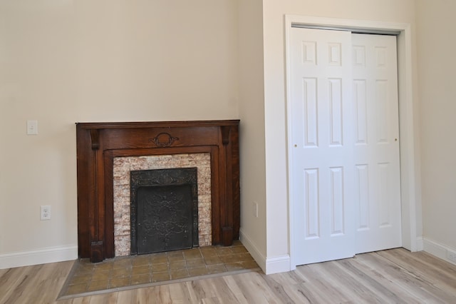 interior details featuring wood finished floors, a fireplace, and baseboards