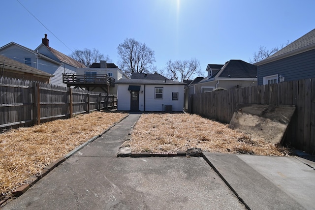 exterior space with central air condition unit, an outdoor structure, and a fenced backyard