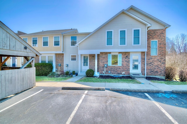 multi unit property featuring brick siding and uncovered parking