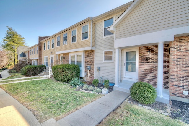 view of property with a front lawn and brick siding