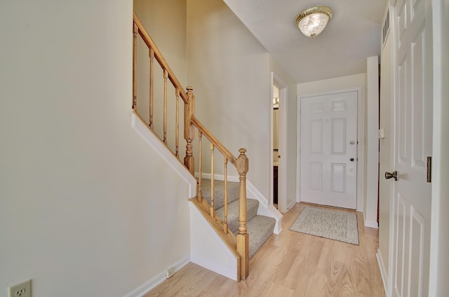 foyer featuring stairway, light wood-type flooring, and baseboards