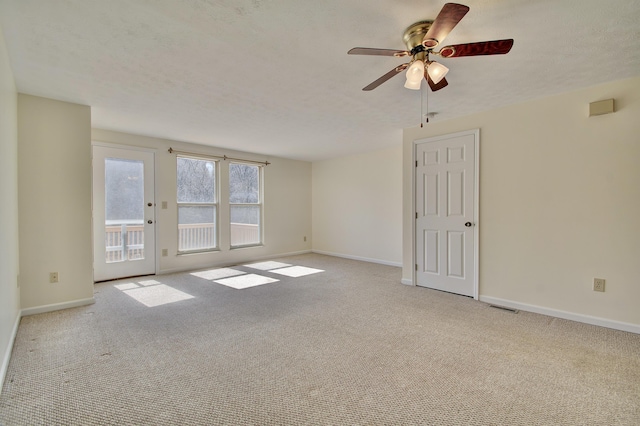 empty room featuring visible vents, a ceiling fan, a textured ceiling, carpet flooring, and baseboards