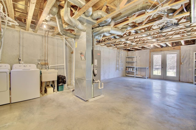 basement featuring washer and clothes dryer, heating unit, french doors, and a sink