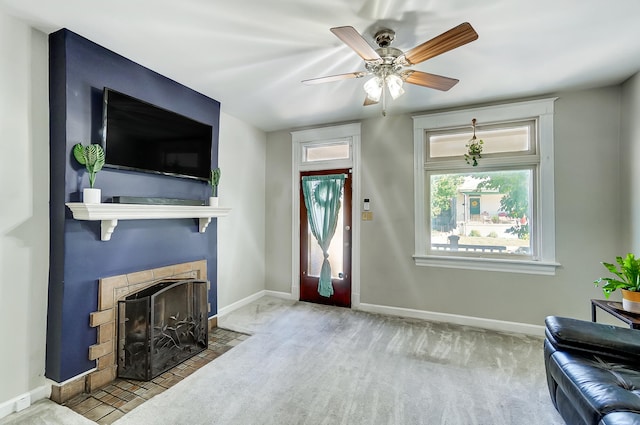 carpeted living area with a fireplace with flush hearth, a ceiling fan, and baseboards