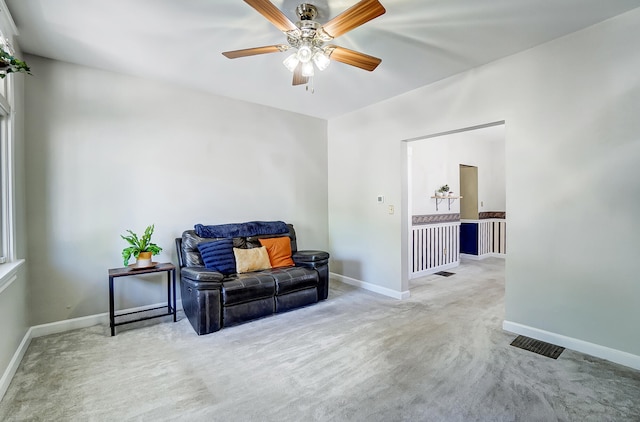 sitting room with a ceiling fan, carpet flooring, visible vents, and baseboards