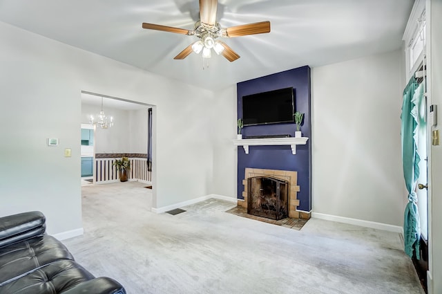 unfurnished living room with carpet flooring, ceiling fan with notable chandelier, a fireplace, and baseboards