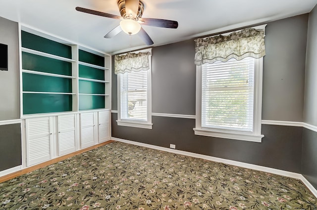 unfurnished dining area with a ceiling fan and baseboards