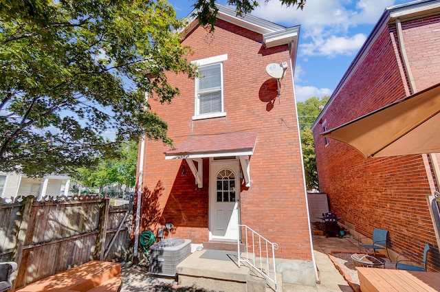 back of house with a patio area, fence, central AC unit, and brick siding