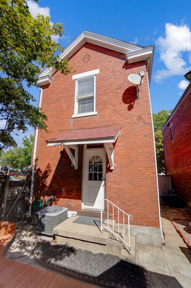 view of front facade featuring brick siding and central AC