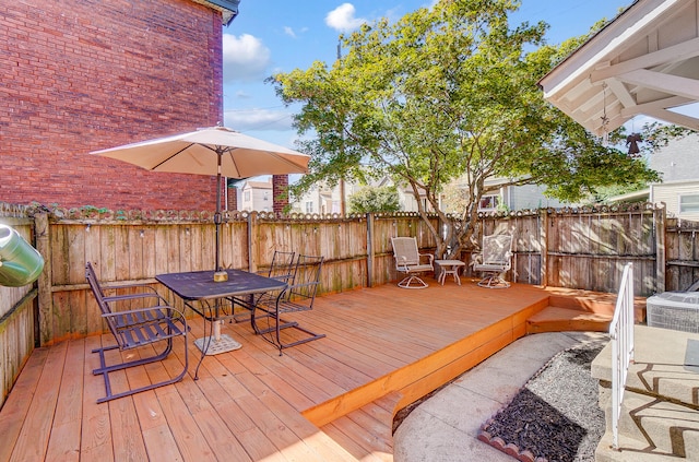 wooden deck with outdoor dining area and fence