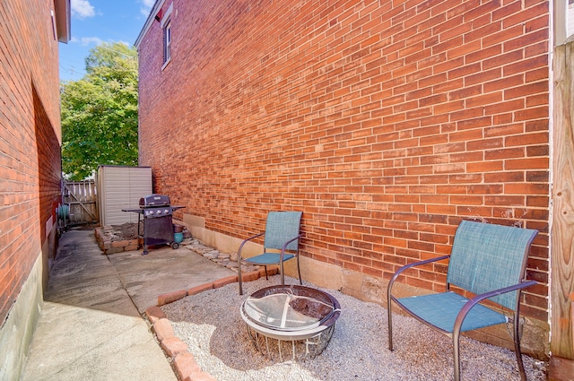 view of patio with a gate, a grill, an outdoor fire pit, and fence