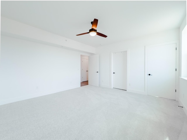 unfurnished bedroom featuring a ceiling fan, baseboards, and light carpet