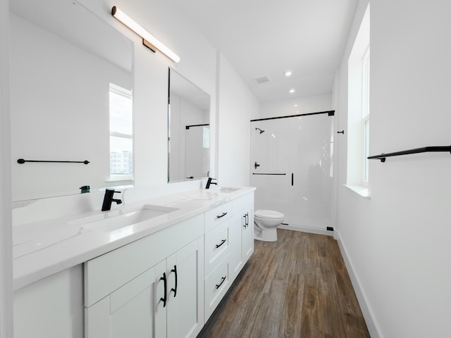 bathroom with a sink, a shower, toilet, and double vanity