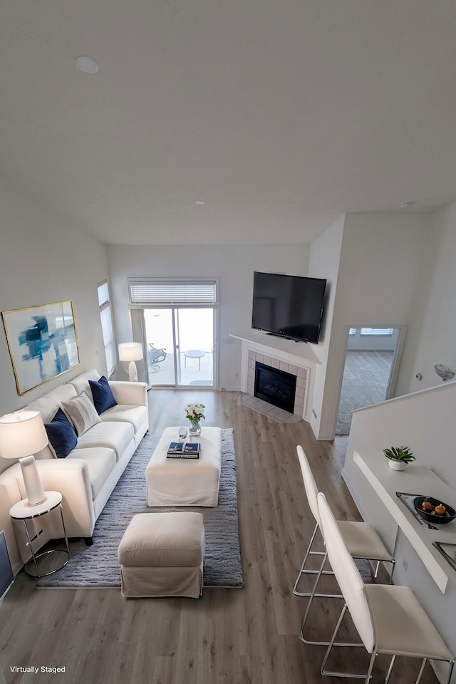 living room with wood finished floors and a tile fireplace