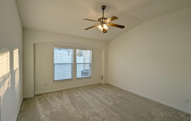 empty room with baseboards, lofted ceiling, carpet floors, and ceiling fan