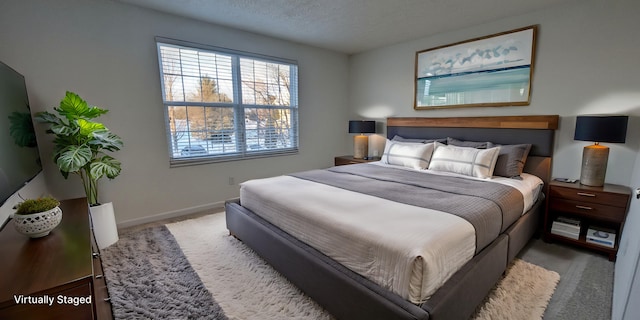 carpeted bedroom with baseboards and a textured ceiling