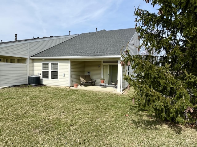 back of property featuring a patio area, central AC unit, a shingled roof, and a yard