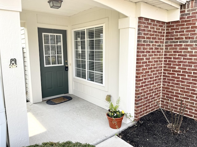 doorway to property featuring brick siding