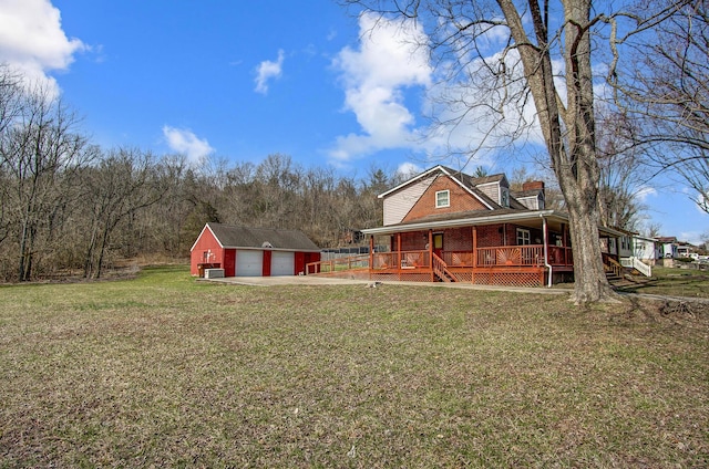 exterior space featuring a detached garage, a porch, a lawn, an outdoor structure, and driveway