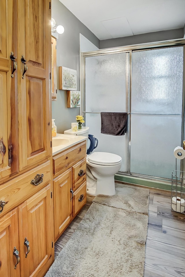 full bath featuring toilet, a stall shower, and vanity