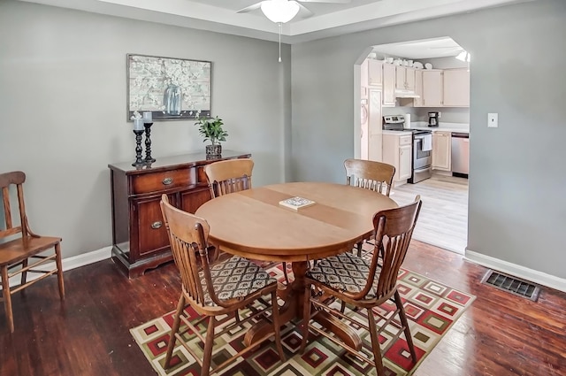 dining space with wood finished floors, visible vents, and baseboards