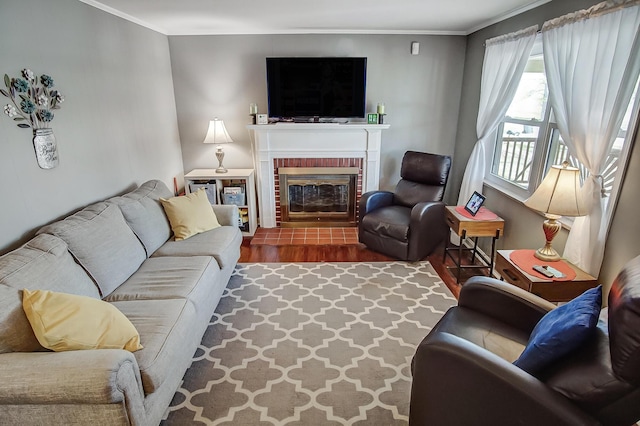 living area featuring crown molding, a brick fireplace, and wood finished floors