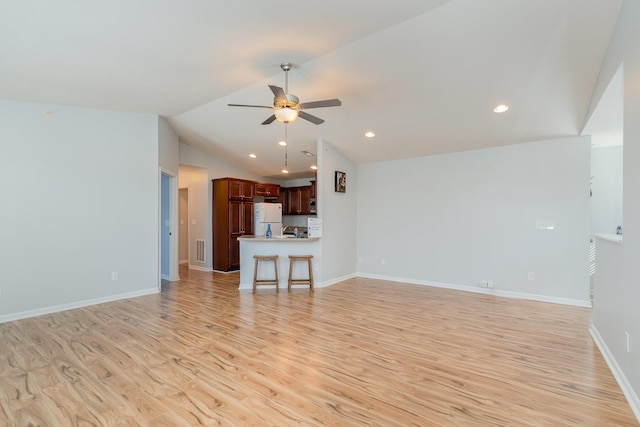 unfurnished living room with light wood finished floors, visible vents, baseboards, ceiling fan, and vaulted ceiling