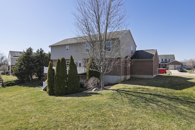 rear view of property with a lawn and brick siding