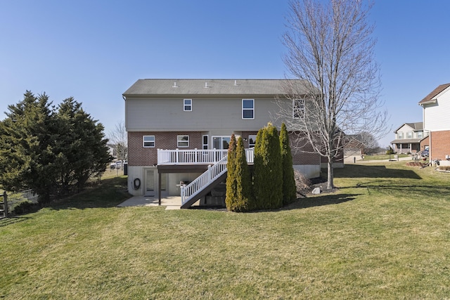 rear view of property with brick siding, stairway, a lawn, and a wooden deck