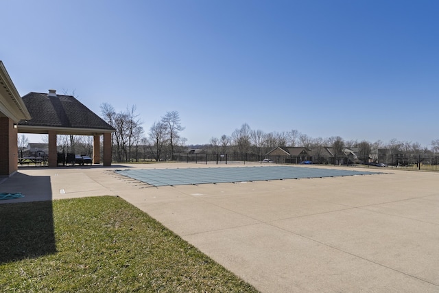 community pool with a patio and fence