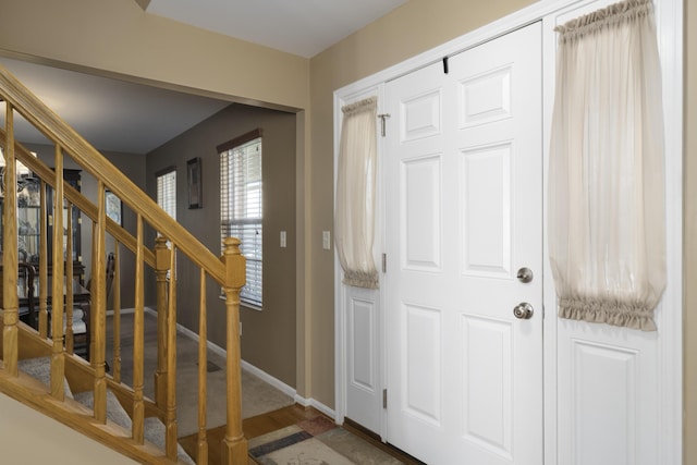 entrance foyer featuring stairway and baseboards