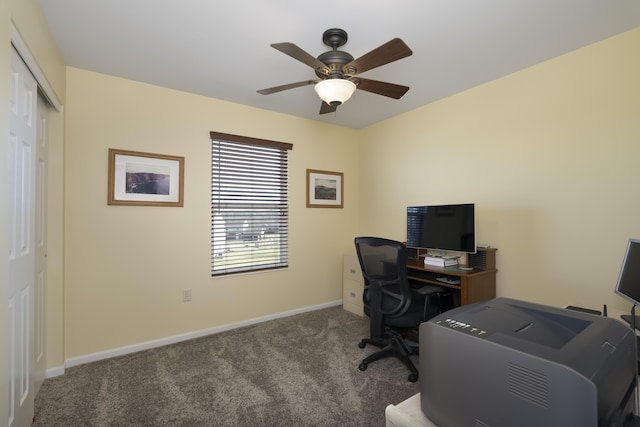 carpeted office with a ceiling fan and baseboards